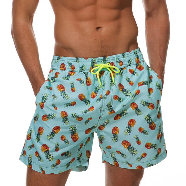 Lichtblauwe zwembroek met ananasprint, gedragen door een man. Trendy herenmode, zomerse stijl, comfortabele pasvorm, strandkleding.