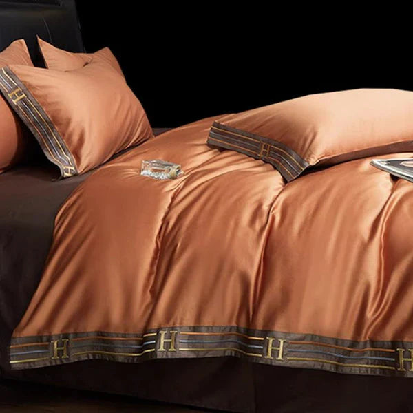Luxe zijden dekbedovertrekset in koperkleur met H-patroon, inclusief kussenslopen en dekbedovertrek, perfect voor een elegante slaapkamerinrichting.