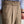 Beige herenbroek met hoge taille, dubbele knoopsluiting en plooien, gedragen met gestreept overhemd. Stijlvolle zakelijke kleding voor mannen.