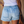 Vrouw in casual outfit met lichtblauwe denim shorts met rafels en zakken, witte top en bruine schoudertas. Zomermode, casual kledingstijl.