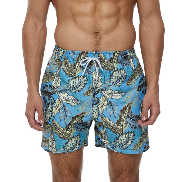 Blauwe zwembroek met tropisch bladpatroon, gedragen door een man. Perfect voor strandmode en zomerse activiteiten. Comfortabele pasvorm.