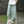 Vrouw draagt losse, lichtgroene linnen broek, casual mode, comfortabele wijde pijpen, buiten op stenen pad, trendy zomeroutfit.