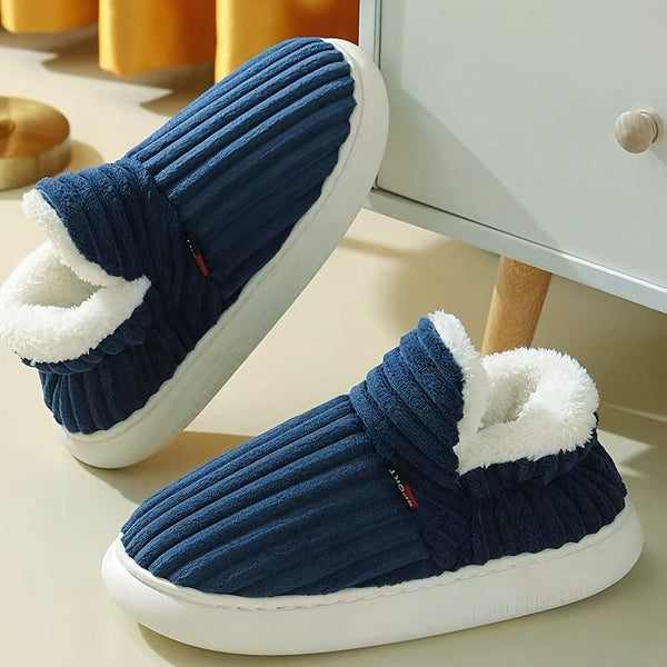 Donkerblauwe pluche pantoffels met witte voering, geribbelde textuur en rubberen zool, perfect voor wintercomfort en warme voeten thuis.