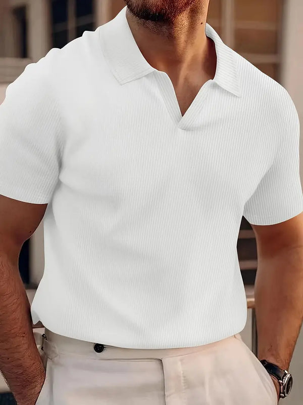Man in witte geribbelde polo, korte mouwen, casual stijl, zomermode, herenkleding, buiten, beige broek, moderne uitstraling.