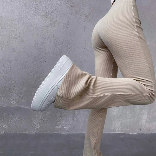 Beige ribfluwelen broek met wijde pijpen, gecombineerd met witte sneakers. Modieuze dameskleding, comfortabele en trendy outfit.