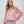 Vrouw in roze bloemenblouse met lange mouwen en gescheurde denim shorts, casual mode, zomerse outfit, trendy dameskleding.