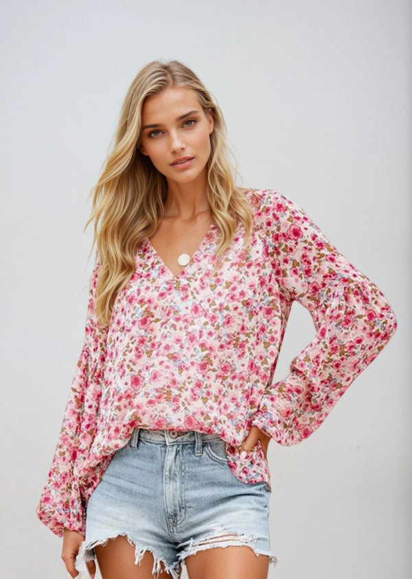 Vrouw in roze bloemenblouse met lange mouwen en gescheurde denim shorts, casual mode, zomerse outfit, trendy dameskleding.