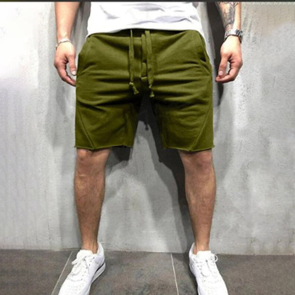 Man in legergroene korte broek, casual stijl, met witte sneakers en wit T-shirt. Trendy herenkleding, comfortabele zomermode.