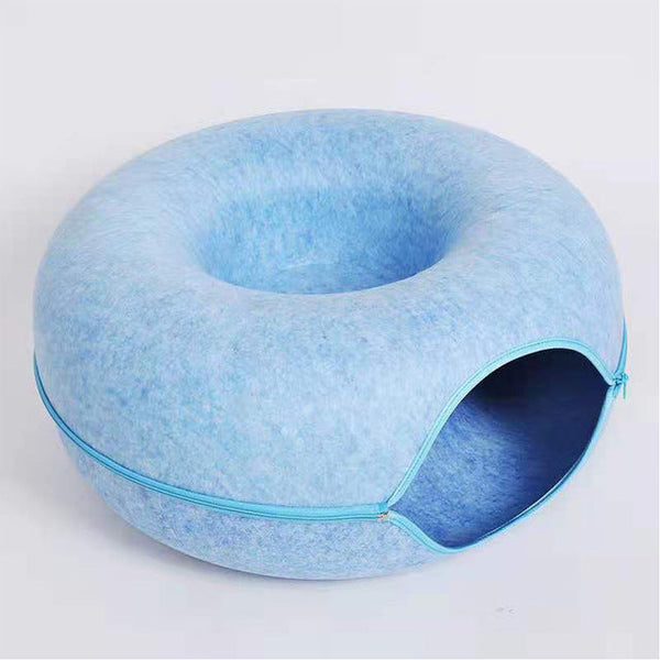 Blauwe kattenmand met ronde vorm en opening, gemaakt van zacht materiaal. Ideaal voor huisdierencomfort en moderne interieurstijl.