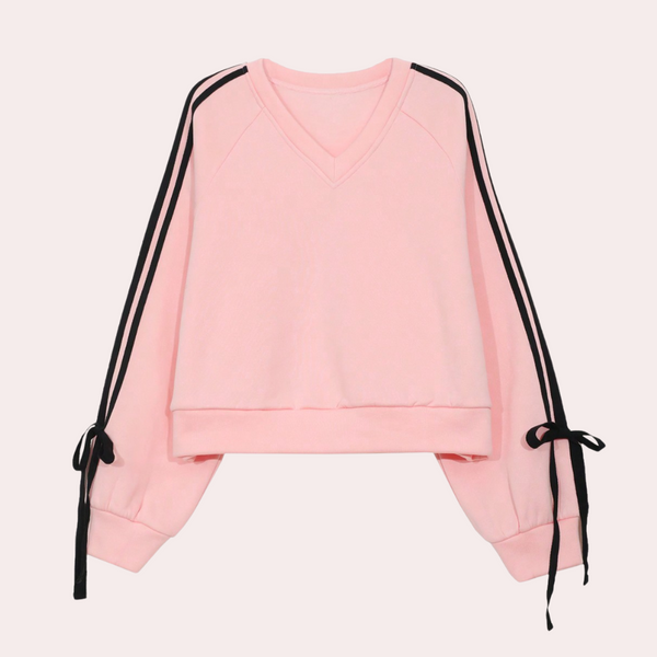 Roze damestrui met V-hals, lange mouwen, zwarte strepen en strikdetails. Trendy en comfortabel, ideaal voor casual outfits.