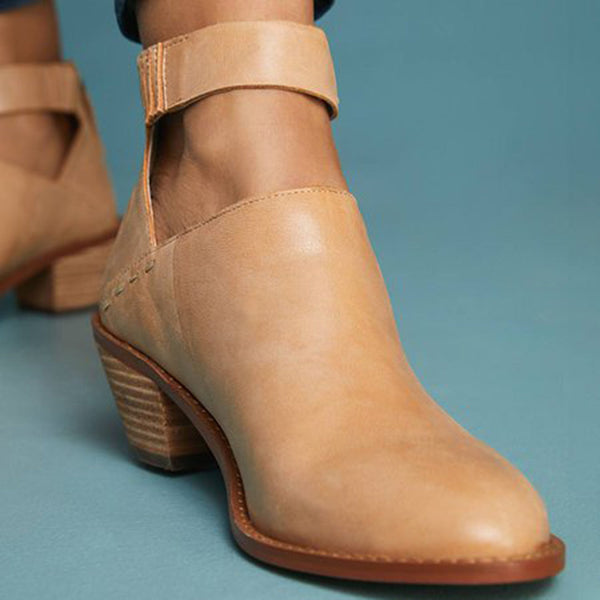 Beige leren dameslaars met blokhak en enkelband op blauwe achtergrond. Stijlvolle en comfortabele enkellaars voor dagelijks gebruik.