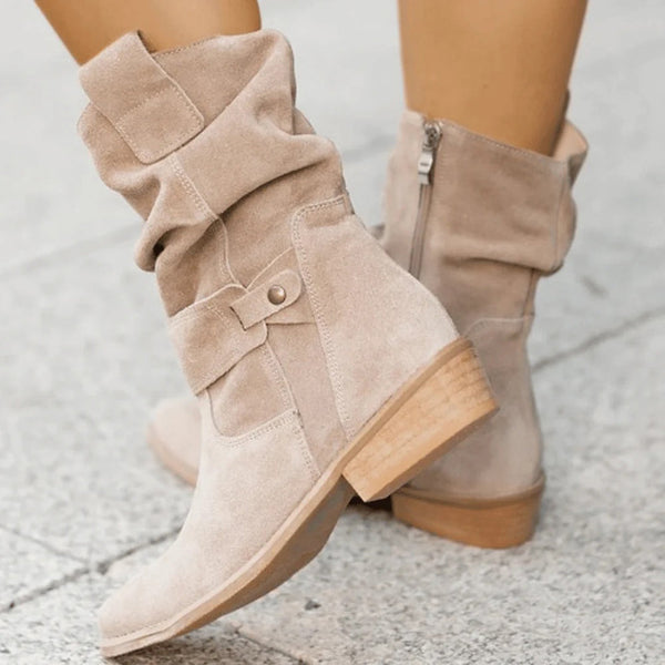 Beige suède dameslaarzen met lage hak, ritssluiting en decoratieve riem. Stijlvolle en comfortabele herfst- en wintermode.