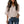 Vrouw in beige blouse met korte mouwen en V-hals, gecombineerd met blauwe jeans. Modieuze dameskleding, casual stijl, trendy outfit.