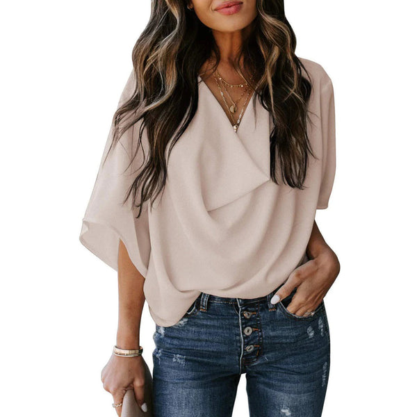 Vrouw in beige blouse met korte mouwen en V-hals, gecombineerd met blauwe jeans. Modieuze dameskleding, casual stijl, trendy outfit.