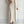 Vrouw in lange beige kabeltrui-jurk met vest, modieuze winterkleding, comfortabele wollen outfit, trendy damesmode, minimalistisch design.