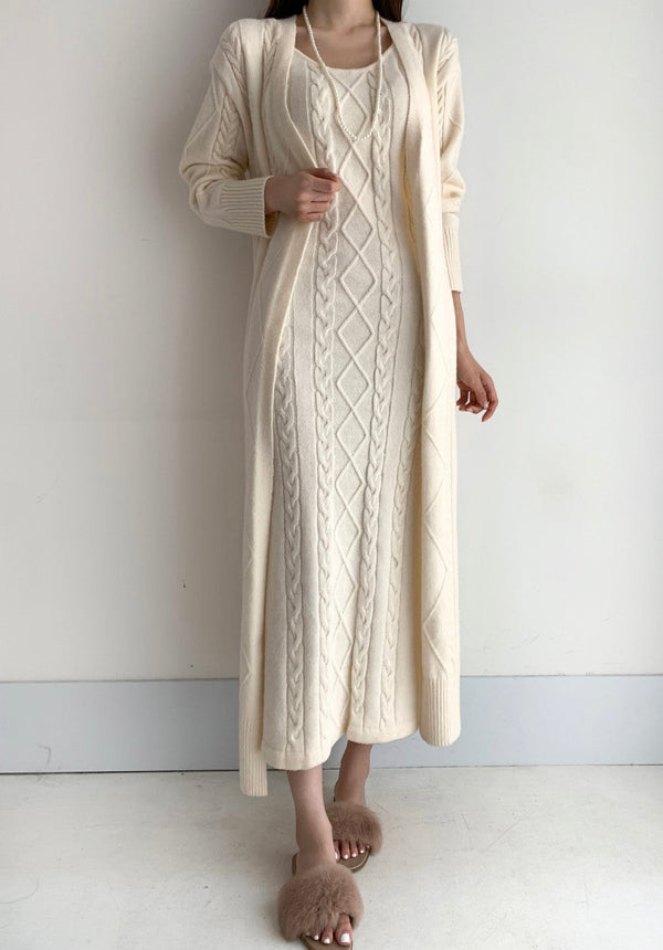 Vrouw in lange beige kabeltrui-jurk met vest, modieuze winterkleding, comfortabele wollen outfit, trendy damesmode, minimalistisch design.