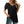 Vrouw draagt zwarte V-hals top met doorschijnende mouwen en spijkerbroek. Modieuze dameskleding, casual stijl, trendy outfit.
