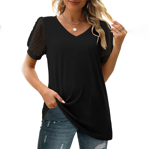 Vrouw draagt zwarte V-hals top met doorschijnende mouwen en spijkerbroek. Modieuze dameskleding, casual stijl, trendy outfit.