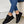 Zwarte sneakers met gouden details, gedragen door persoon in blauwe jeans. Stijlvolle casual schoenen, perfect voor dagelijks gebruik.