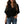 Vrouw in zwarte blouse met korte mouwen en V-hals, gecombineerd met blauwe jeans met knoopsluiting. Modieuze casual dameskleding.