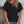Vrouw in zwarte geperforeerde blouse, korte mouwen, gouden ketting, casual look, zomermode, trendy dameskleding, denim shorts.