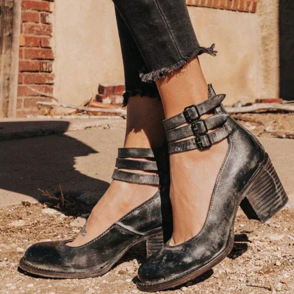 Zwarte leren enkellaarsjes met dubbele gespsluiting en blokhak, gedragen door model op straat. Trendy damesmode, casual en stijlvol schoeisel.