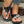 Zwarte damessandalen met bloemenversiering, open teen en platte zool. Perfect voor zomerse casual outfits. Comfortabele en stijlvolle slippers.