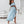 Vrouw in elegante blauwe off-shoulder crop top en lange rok, stijlvolle zomermode, binnenhuis, witte achtergrond, hoge hakken.