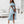Vrouw in elegante blauwe off-shoulder crop top en asymmetrische rok, zomerse outfit, mode, stijlvolle kleding, binnenhuis, hoge hakken.