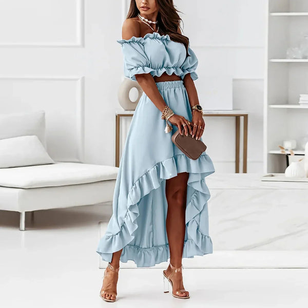Vrouw in elegante blauwe off-shoulder crop top en asymmetrische rok, zomerse outfit, mode, stijlvolle kleding, binnenhuis, hoge hakken.