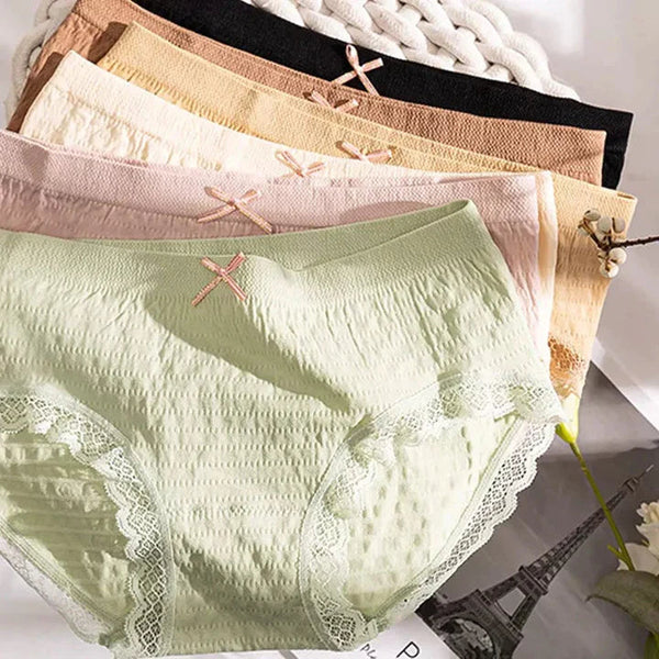 Vijf damesonderbroeken in pastelkleuren met kanten details en strikjes, gestapeld op een witte achtergrond. Comfortabele lingerie, modieuze slips.