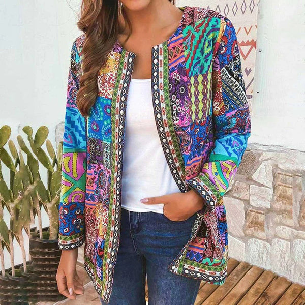 Vrouw draagt kleurrijke boho jas met etnische patronen, gecombineerd met een witte top en jeans. Perfect voor casual en trendy mode.