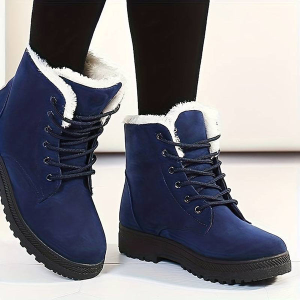 Blauwe winterlaarzen met witte voering, stevige rubberen zool en veters. Ideaal voor koude weersomstandigheden. Comfortabele en modieuze dameslaarzen.