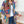Vrouw draagt kleurrijke bohemian jas met etnische patronen, gecombineerd met witte top en jeans. Trendy damesmode, boho-chic stijl, casual outfit.