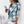 Vrouw in blauwe geruite blazer, modetrend 2023, stijlvolle dameskleding, casual chic outfit, witte top en broek, moderne zakelijke look.