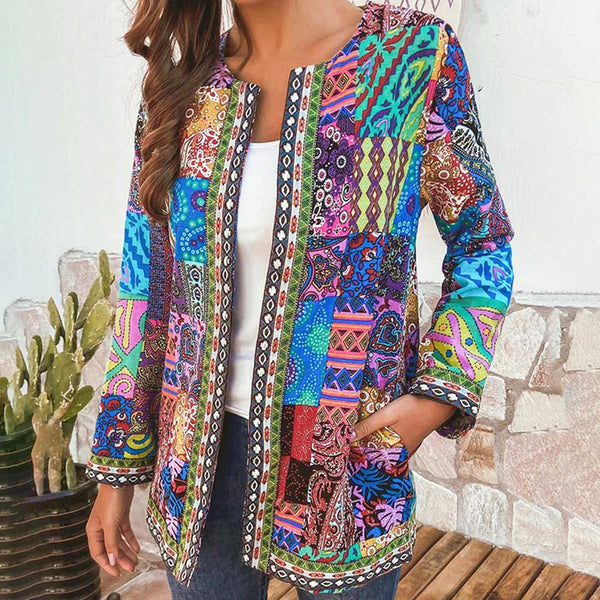 Vrouw draagt kleurrijke patchwork jas met etnische patronen, ideaal voor bohemian mode. Perfect voor herfst en lente. Cactussen op achtergrond.