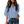 Vrouw in lichtblauwe blouse met V-hals en driekwart mouwen, gecombineerd met donkere jeans. Modieuze dameskleding, casual stijl.