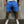 Man in blauwe korte broek en witte sneakers tegen grijze achtergrond. Casual zomeroutfit, mode voor heren, comfortabele sportieve stijl.