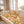 Hond liggend op kleurrijke bohemian deken op beige bank in zonnige woonkamer. Boho interieur, huisdier comfort, gezellige sfeer.