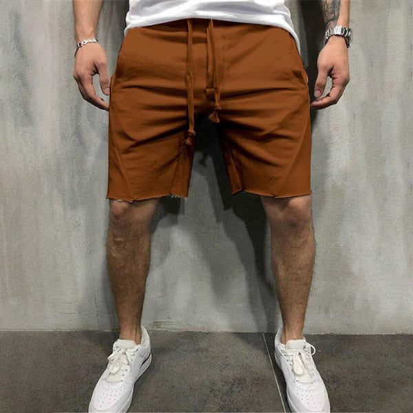 Bruine casual korte broek voor heren, gedragen met witte sneakers. Perfect voor zomermode en streetwear. Comfortabele pasvorm, trendy stijl.