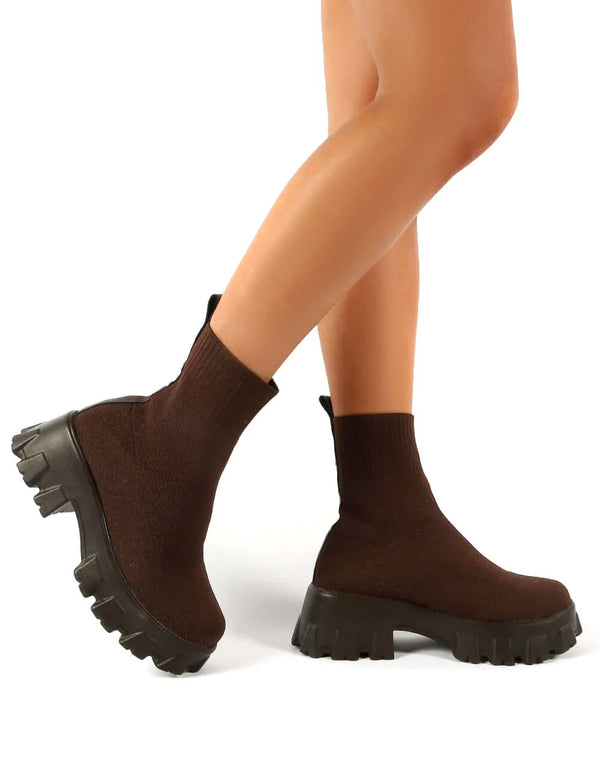 Bruine soklaarzen met dikke zool, gedragen door model. Trendy damesmode, comfortabele pasvorm, perfect voor herfst- en winteroutfits.