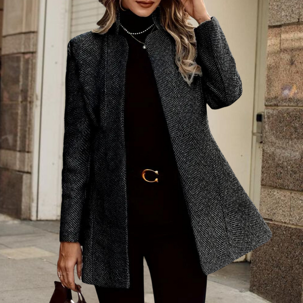Zwarte wollen damesjas, elegant en stijlvol, met visgraatpatroon. Perfect voor herfst- en wintermode. Geschikt voor casual en zakelijke outfits.
