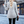 Vrouw in grijze wollen jas op straat, rugaanzicht. Stijlvolle wintermode, stedelijke achtergrond. Elegante damesjas, casual chic look.