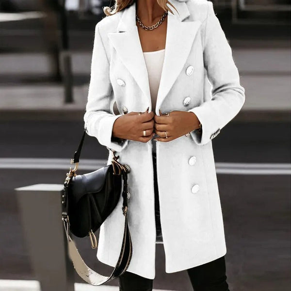 Witte damesjas met dubbele rij knopen, gedragen door model met zwarte handtas. Stijlvolle wintermode, elegante dameskleding, trendy jas.