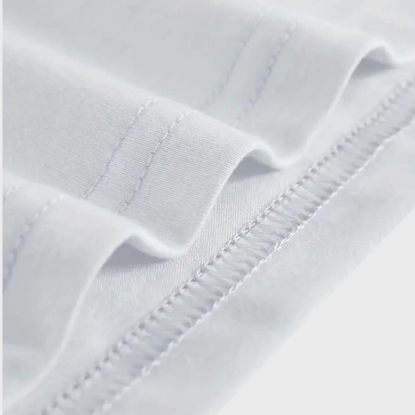 Witte katoenen stof close-up met zichtbare stiksels en textuur, ideaal voor kledingproductie. Hoogwaardige textielmaterialen, duurzaam en zacht.