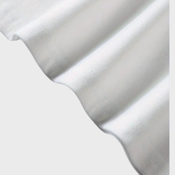 Witte katoenen stof met golvende rand, close-up. Hoogwaardige textieltextuur, geschikt voor kleding en interieurdecoratie.