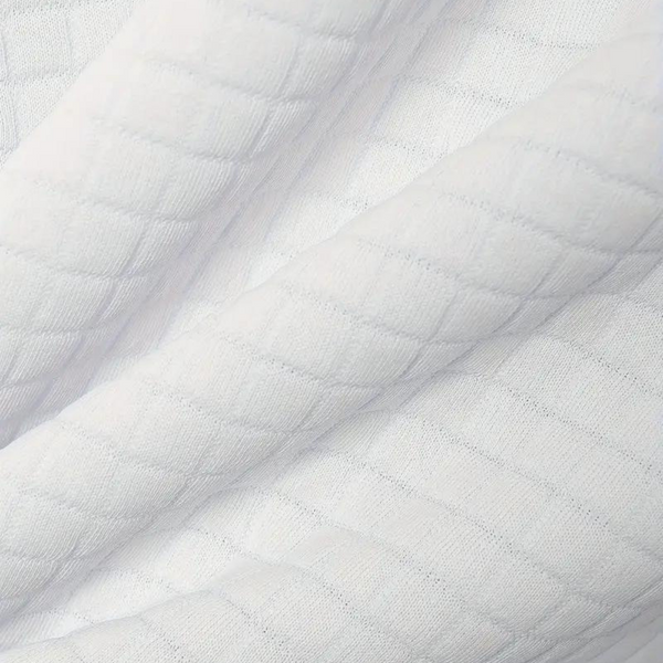Witte gewatteerde stof met ruitpatroon, ideaal voor kleding en interieur. Hoogwaardige textiel, zacht en duurzaam. Perfect voor naaiprojecten.