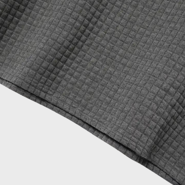Grijze gewafelde stof met vierkant patroon, ideaal voor interieurdecoratie en kleding. Hoogwaardige textieltextuur, veelzijdig en stijlvol.
