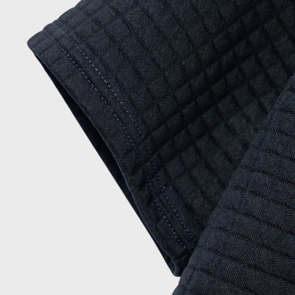 Donkerblauwe gewatteerde stof, close-up van textuur en stiksels, geschikt voor kleding en interieur, hoogwaardige textielmaterialen.
