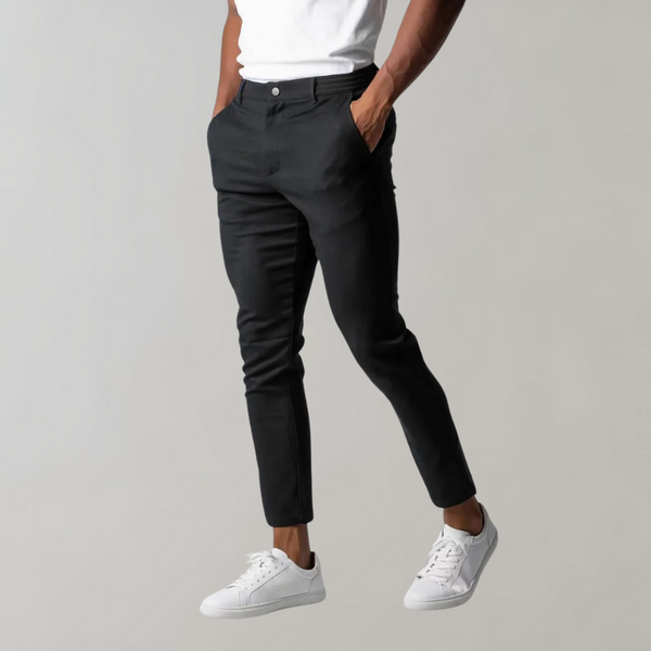 Zwarte chino broek voor heren, stijlvol en modern, gecombineerd met witte sneakers. Perfect voor casual en zakelijke outfits.